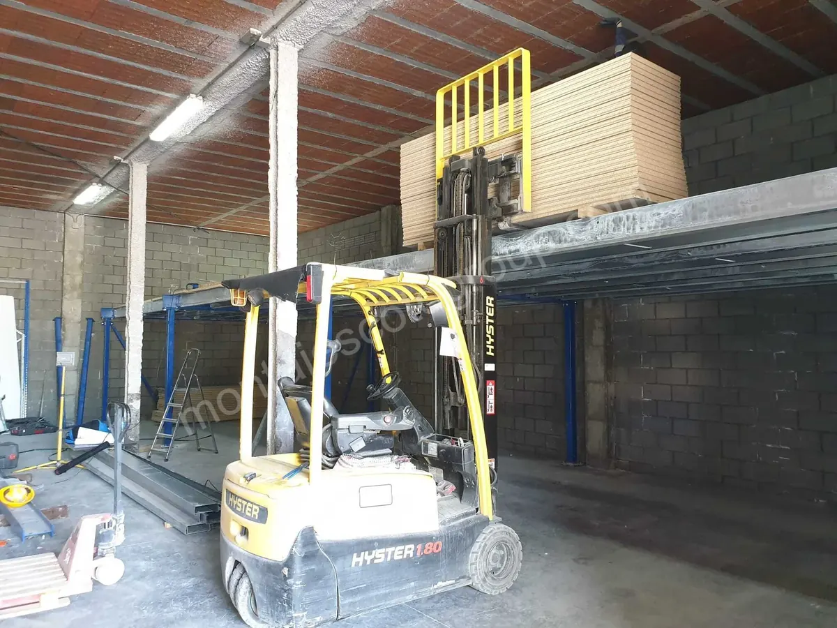 Carretilla elevadora subiendo paneles a la plataforma de una entreplanta metálica en construcción