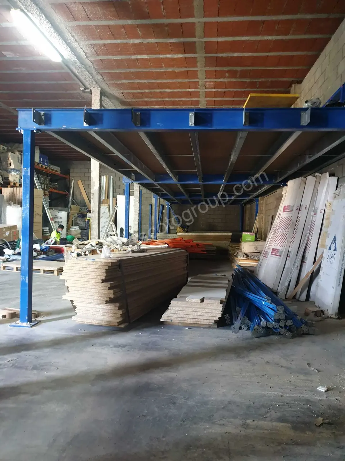Estructura azul de una entreplanta metálica con vigas y plataforma sobre el suelo de la nave